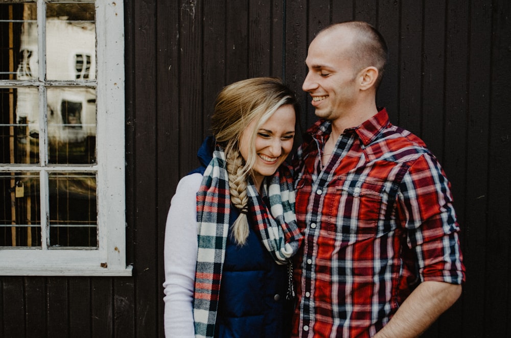 man and woman standing near brown wall