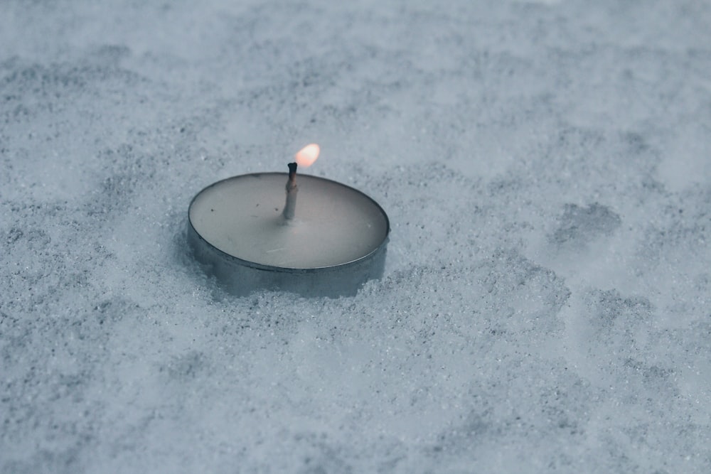 Nahaufnahme der Teelichtkerze auf dem Schneefeld