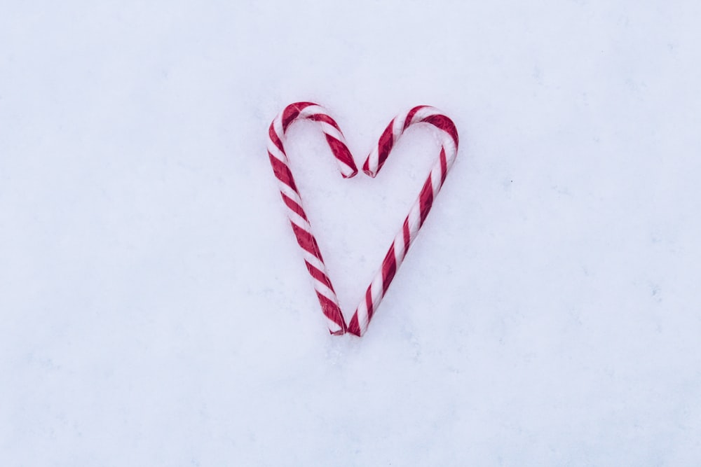two red-and-white candy canes on white surface