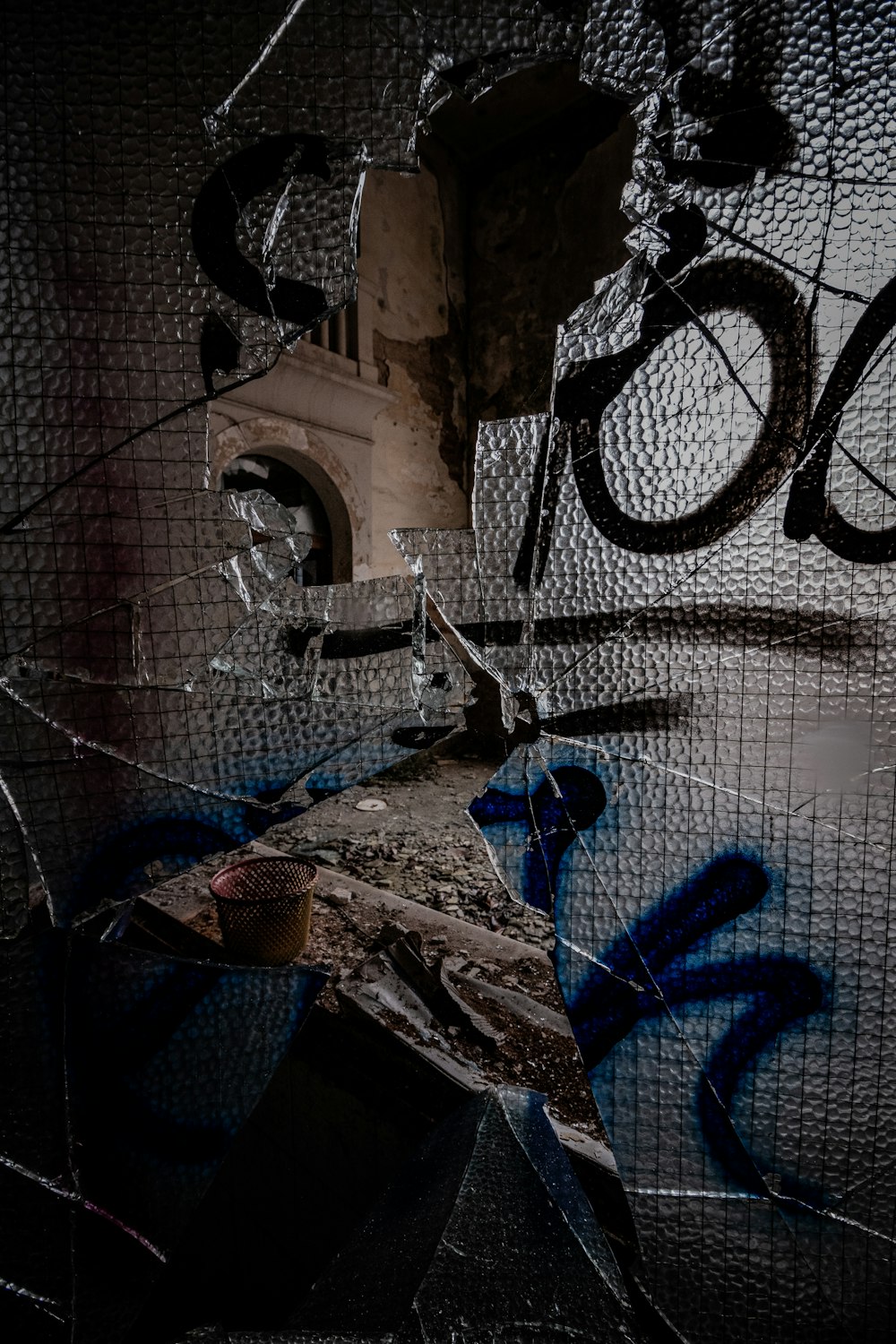 a broken window with graffiti on it