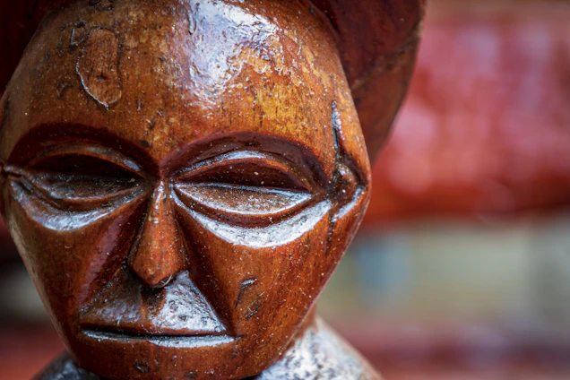 Close-up of a wooden portrait with intricate pyrography details highlighting facial features.