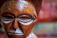 Close-up of a beautifully carved wooden mask with intricate patterns and rich earthy tones.