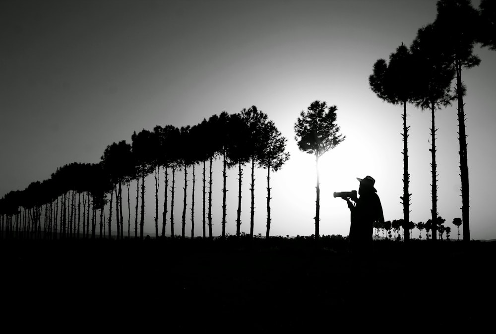 silhouette photography of person standing near trees