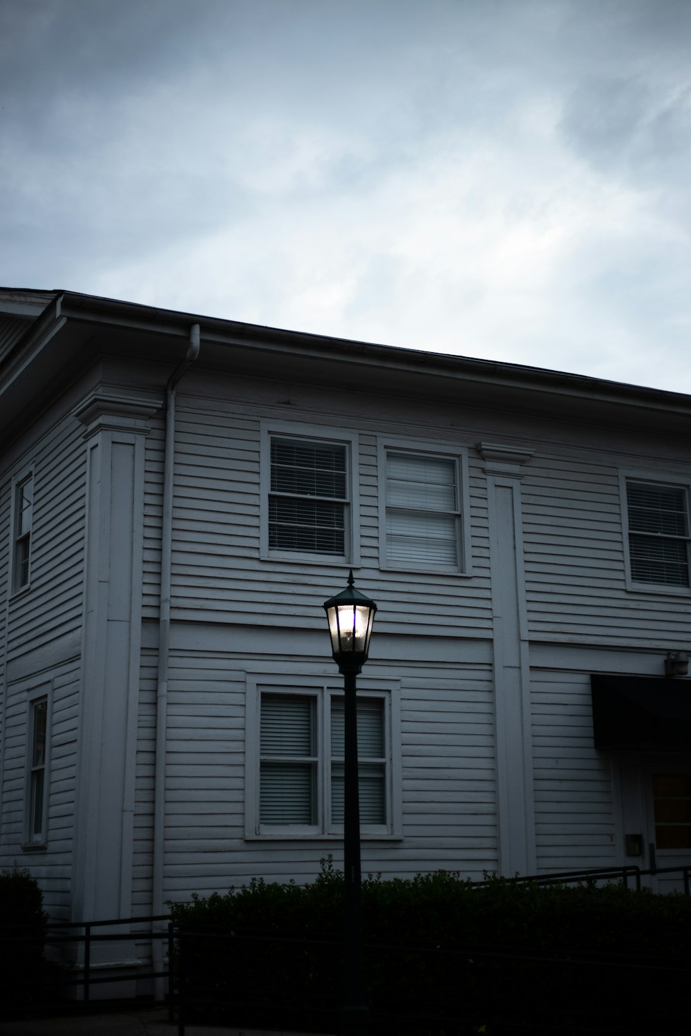 lighted post lamp near white house