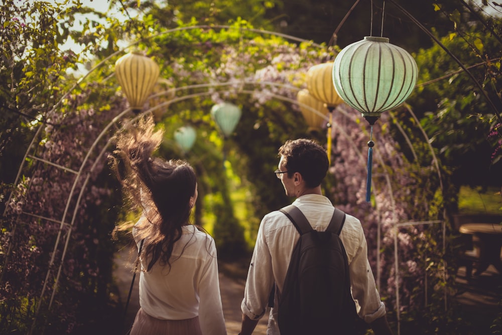selective focus photography of couple walking near trees