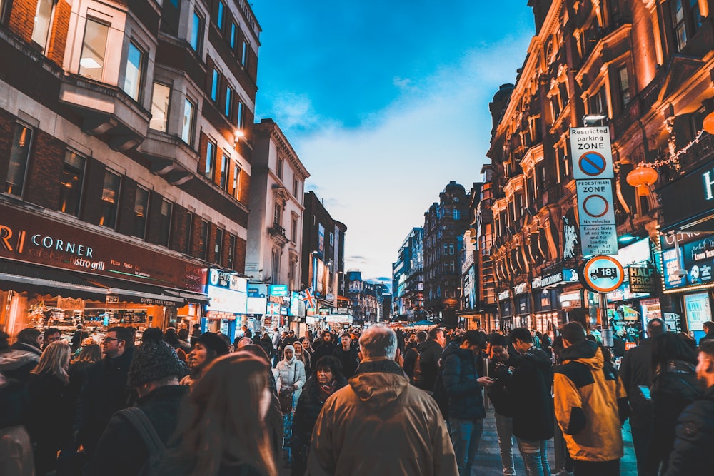 people walking on street between commercial buildings