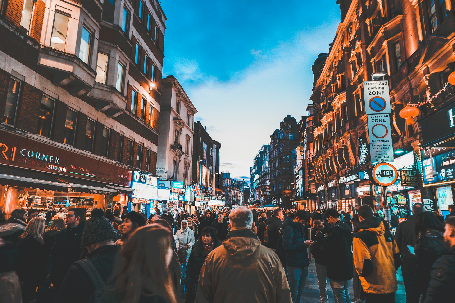 people walking on street between commercial buildings