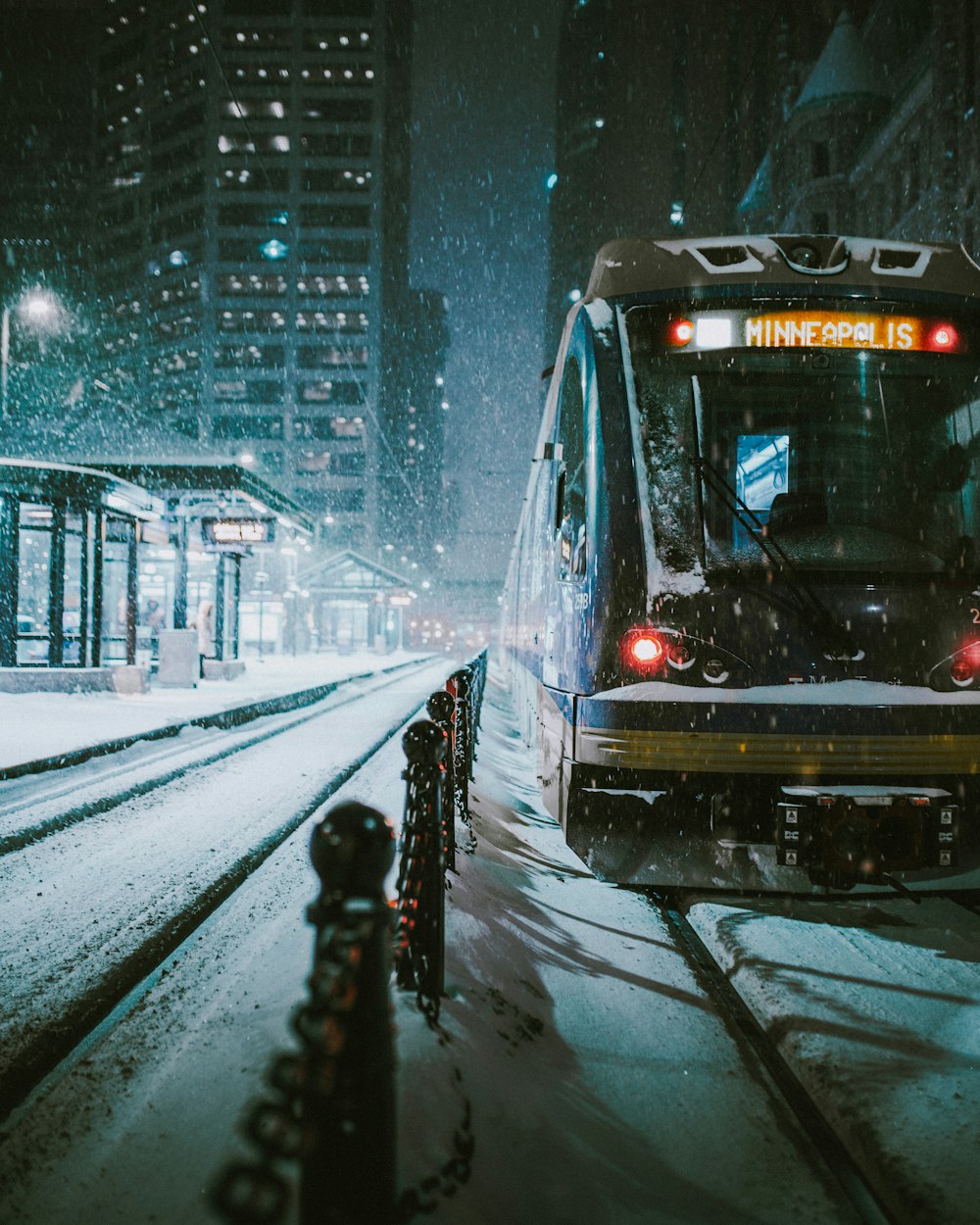 black and brown train near the building during nighttime