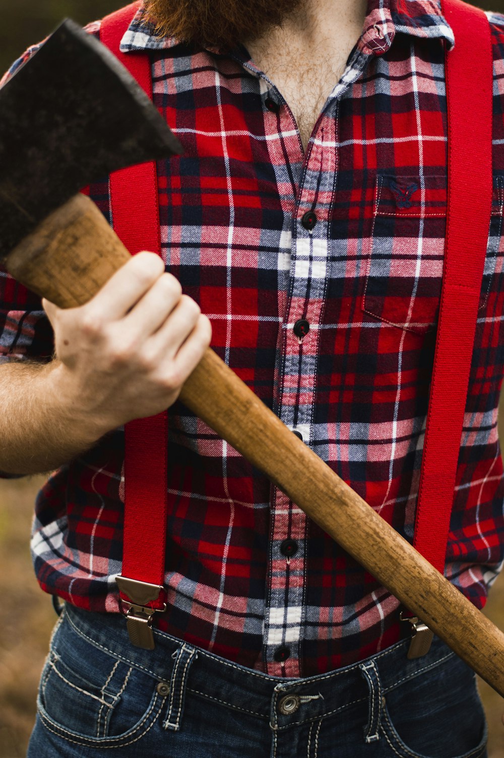 person carrying brown handle axe