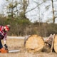 person using chainsaw in front of tree log