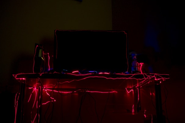 Futuristic gaming studio workspace illuminated by neon lights with developers collaborating on game design.