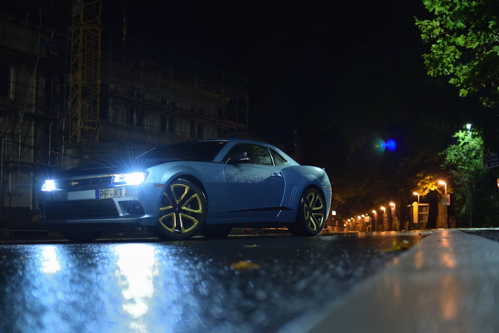 blue sports coupe on road during nighttime