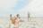 A smiling woman enjoying a sunny beach vacation, symbolizing positive community experiences.
