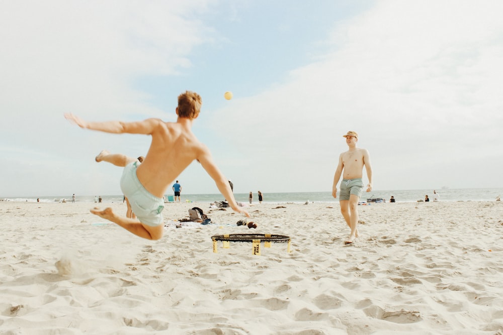two men playing on seashore
