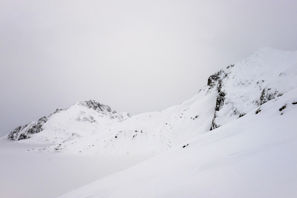 montanha coberta de neve sob nuvens brancas