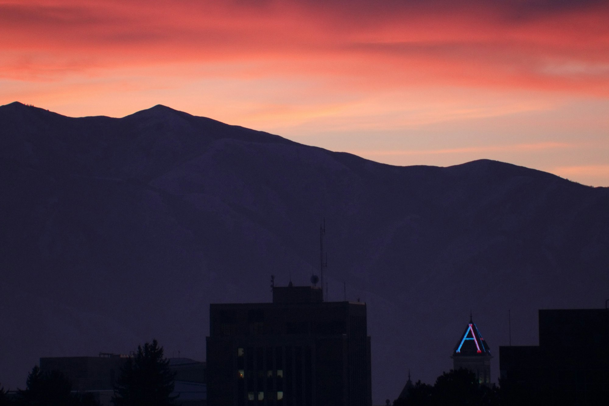 Sunset at night against the campus of Utah State University.  When USU has a victory, they light the “A” (for Aggies) blue.