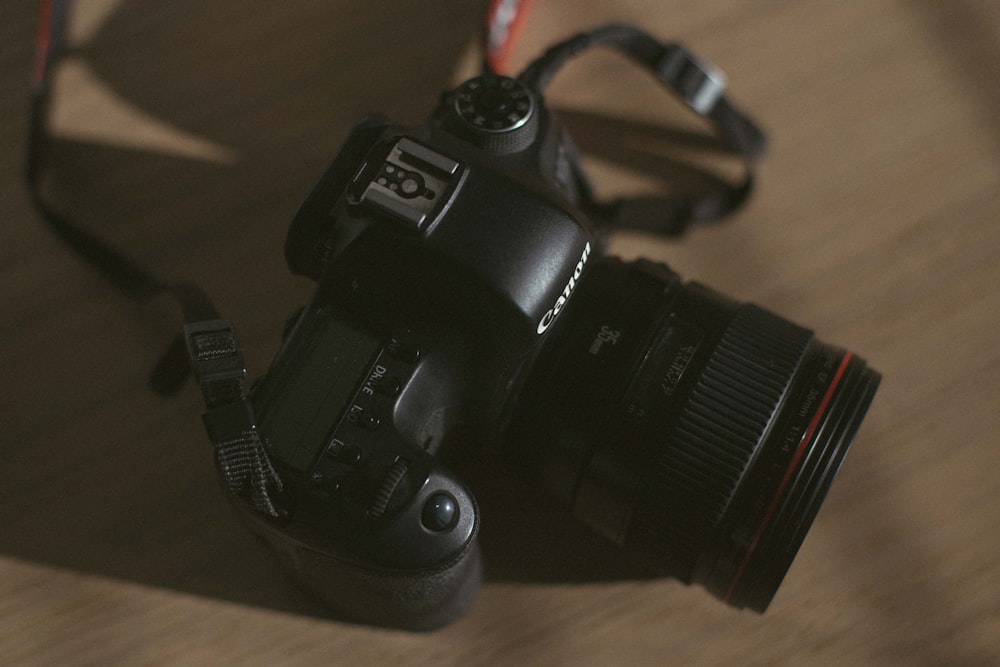 black DSLR camera on brown wooden surface