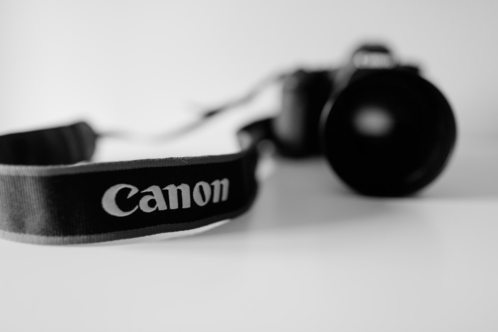 câmera Canon DSLR preta na foto em tons de cinza