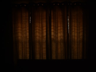 Rich, heavy blackout curtains framing a bedroom window at dusk.