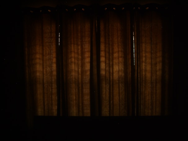 Dark charcoal blackout curtains perfectly blocking daylight in a home theater room.