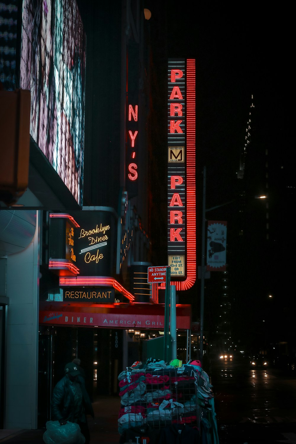 man standing near commercial buildings during nighttime