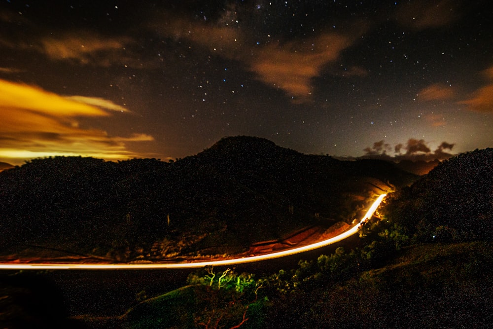 a long exposure photo of a road at night