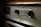 A close-up view of the control panel of a vintage General Electric automatic oven. The panel has a metallic finish with two black knobs and engraved text, surrounded by textured metal.