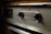 A close-up view of the control panel of a vintage General Electric automatic oven. The panel has a metallic finish with two black knobs and engraved text, surrounded by textured metal.