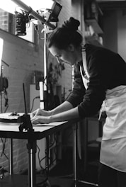 A professional artist arranging stage design elements in a creative studio space.