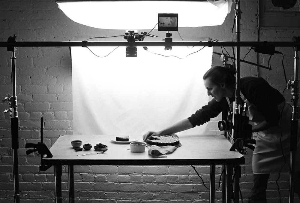 grayscale photo of woman holding baking pan