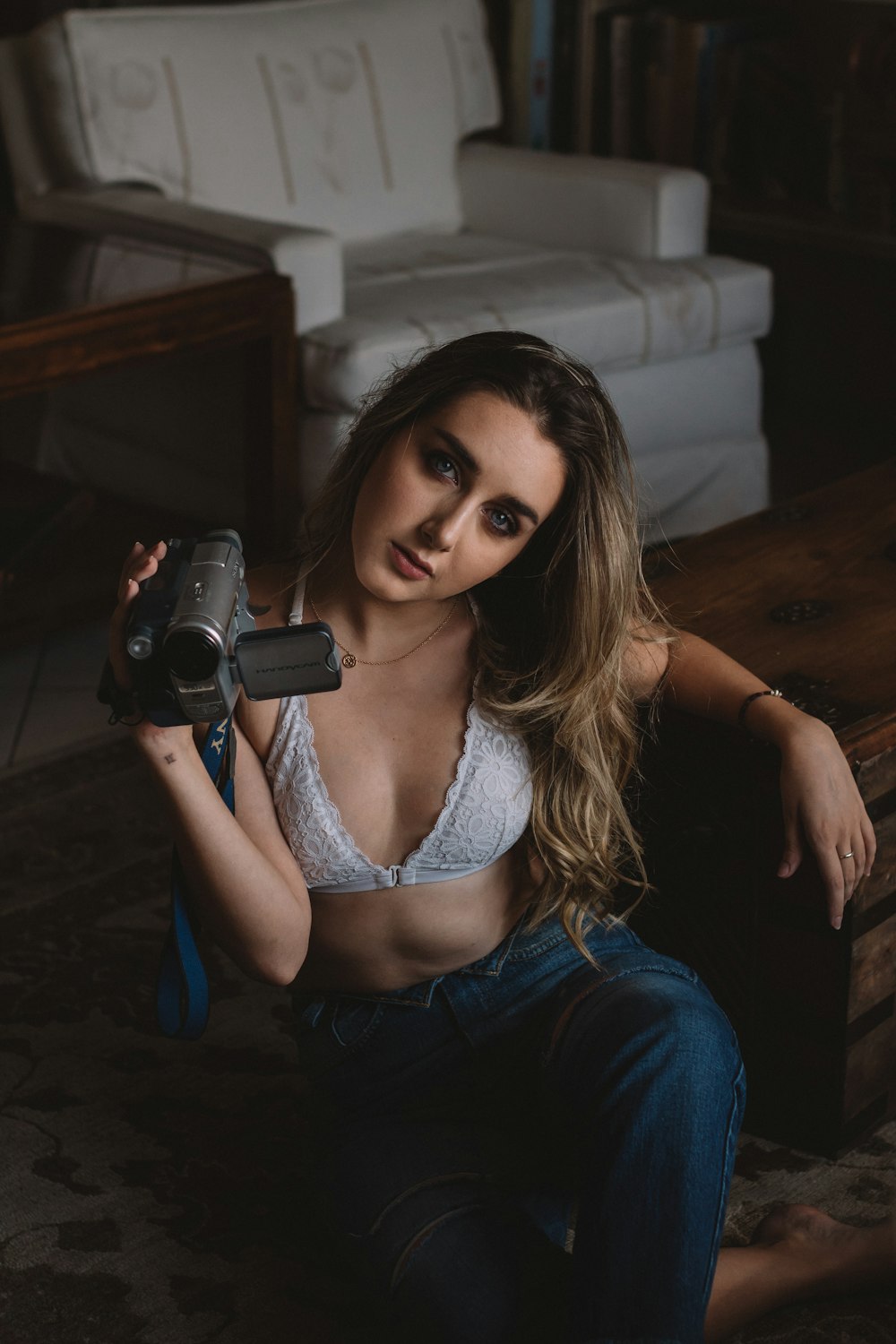 woman holding gray video camera sitting on floor