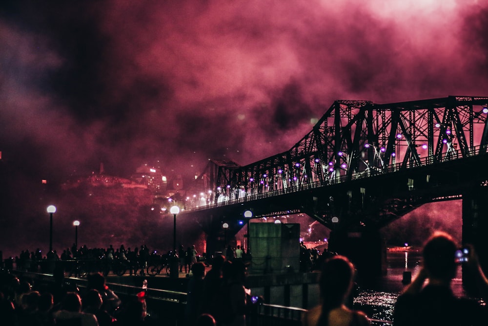 concrete bridge at night time with red smoke