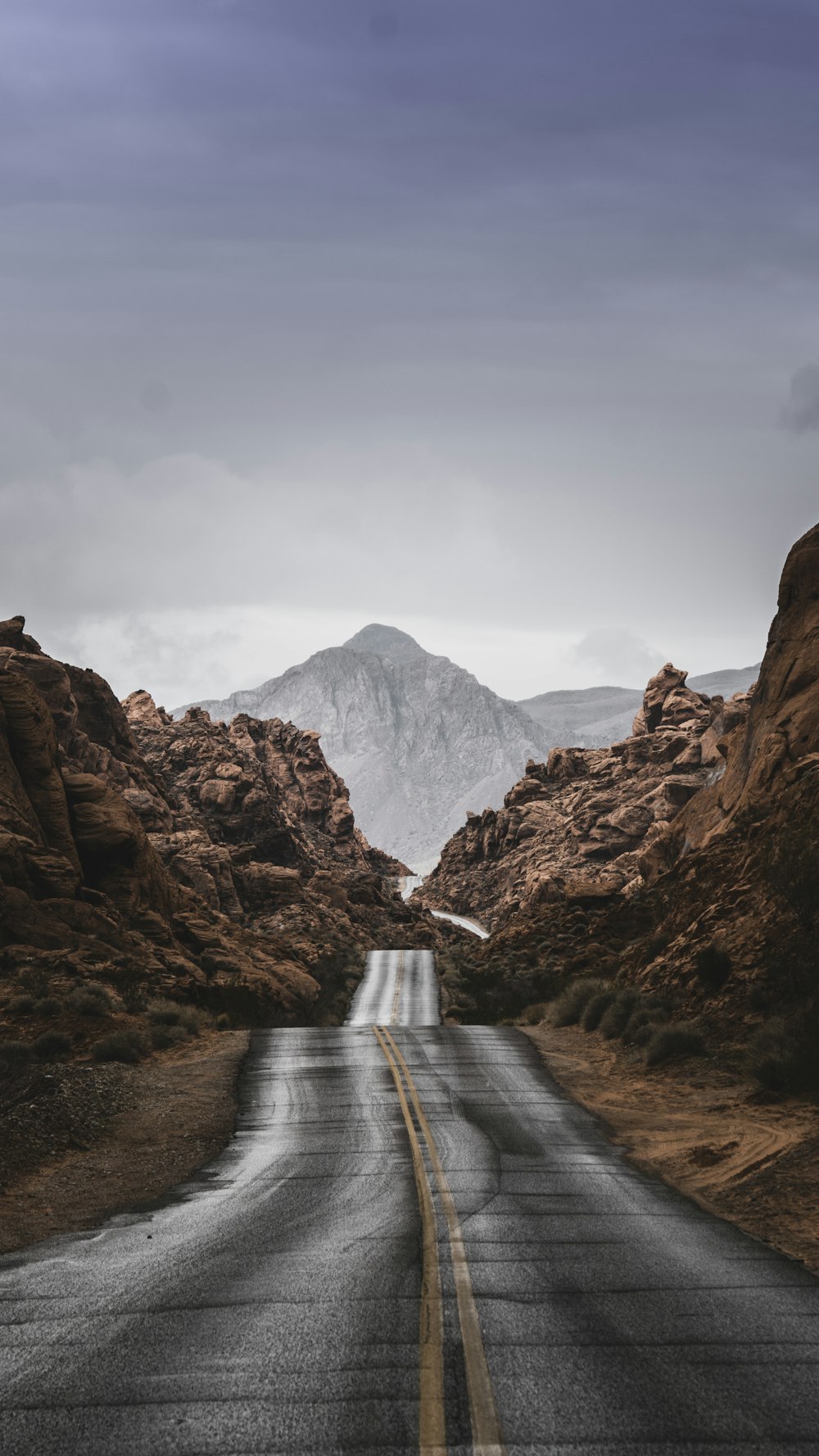 an empty road with a mountain in the background