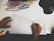 Close-up of hands sketching land survey details on a drafting table.