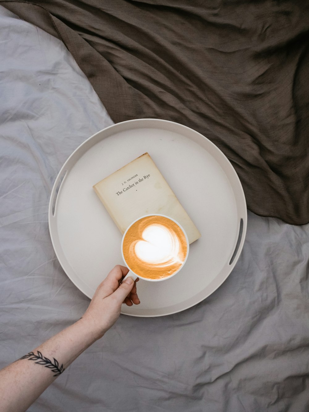 person holds coffee latte with heart design