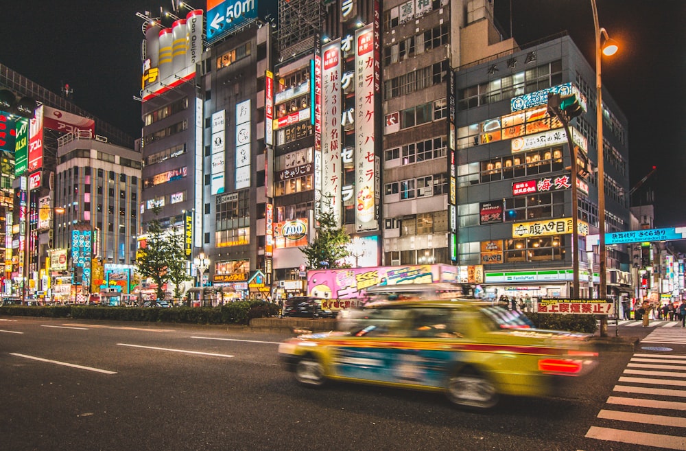 yellow taxi cab crossing on road during nighttime