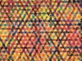 A complex geometric pattern composed of overlapping film strips arranged in crisscross and triangular formations, creating a kaleidoscopic effect. The image is vibrant with a mosaic of colors and textures.