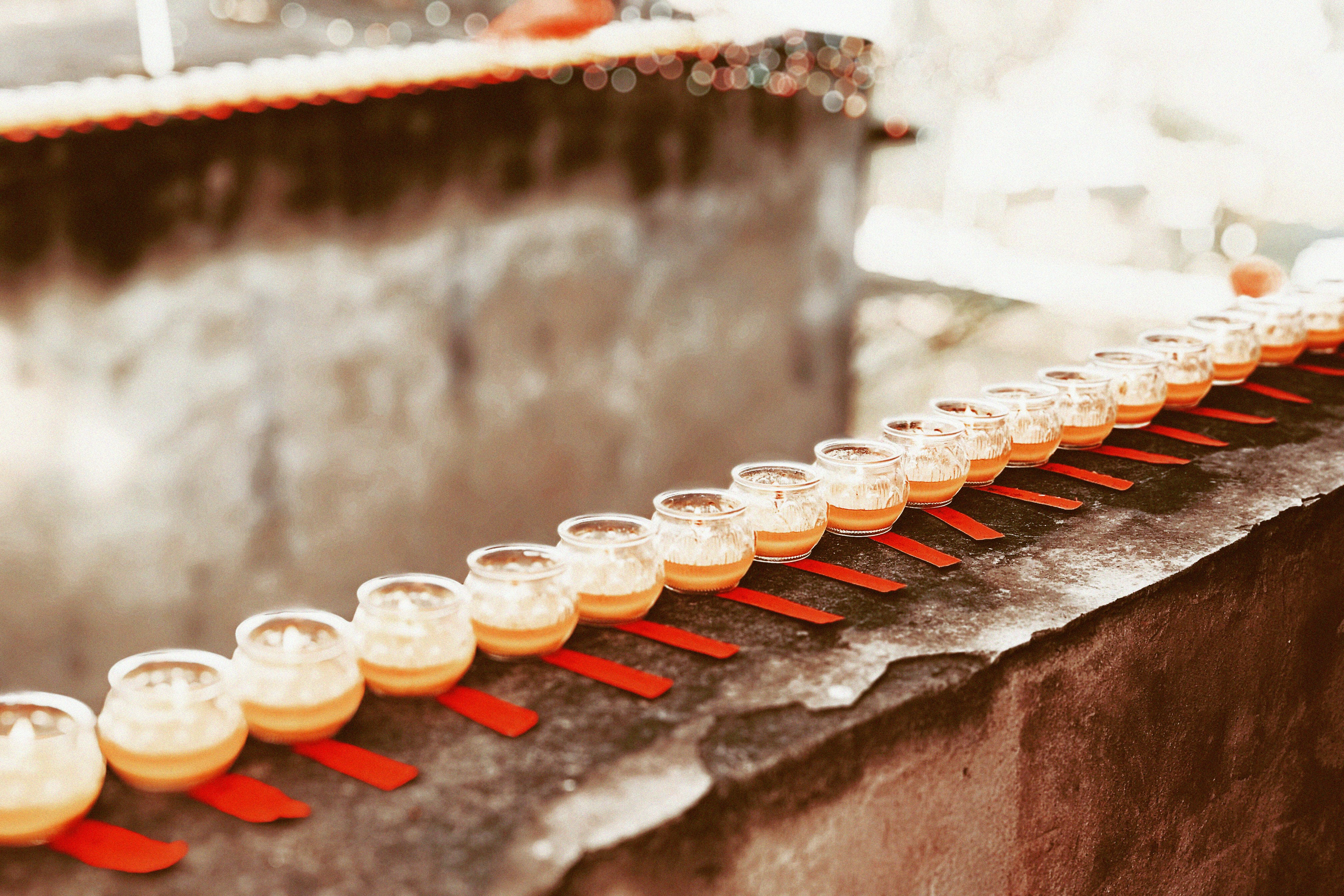 Long row of small tasting glasses on a stone ledge