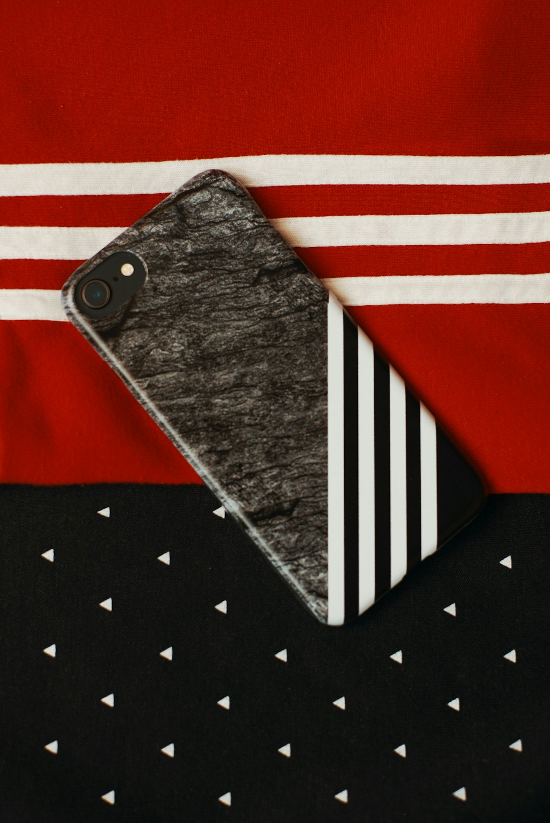 black iPhone on red and white textile