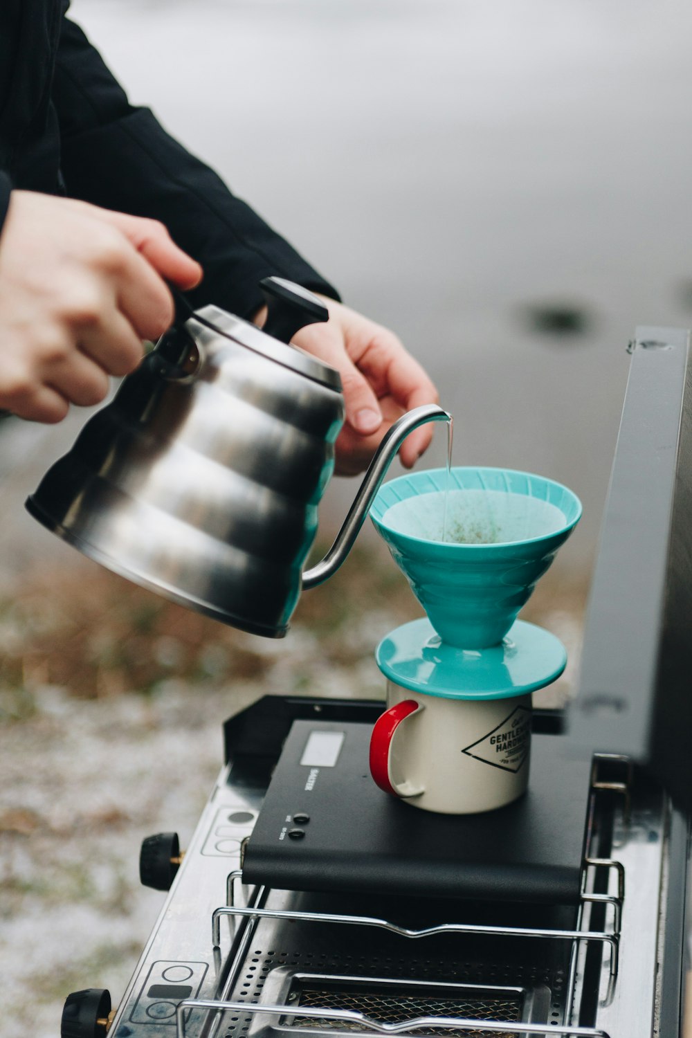 person pouring tea on white ceramic mug