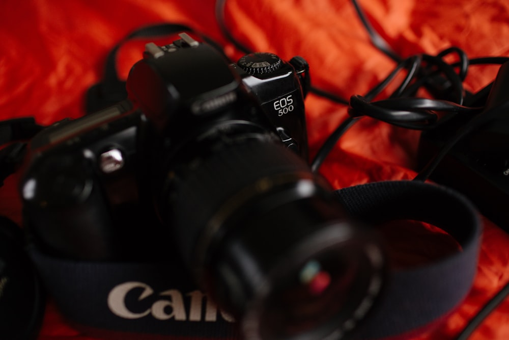 black Canon EOS 50D camera on orange textile