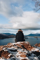 man sitting on mountain peak