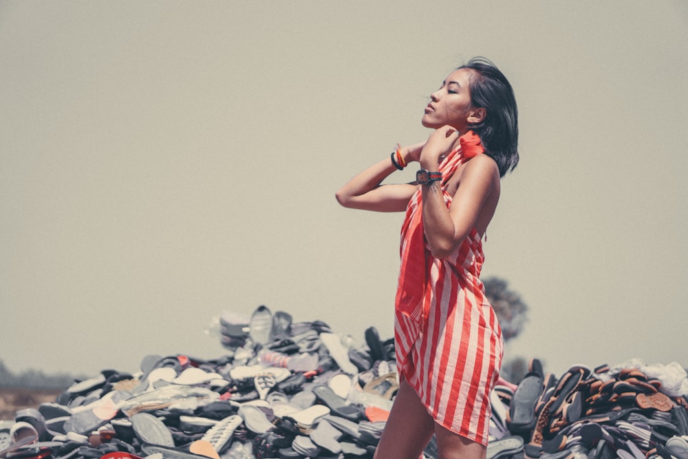 standing woman in front of pile of shoes