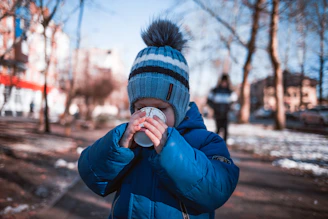 boy holding white cup