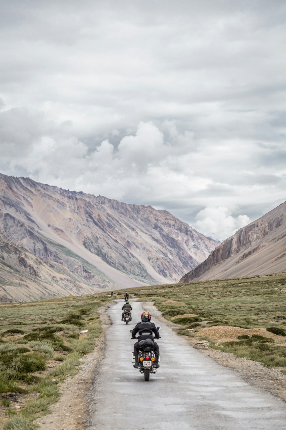 due motociclette che guidano sulla strada grigia
