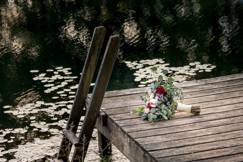 wedding bouquet on dock near ladder by the lake