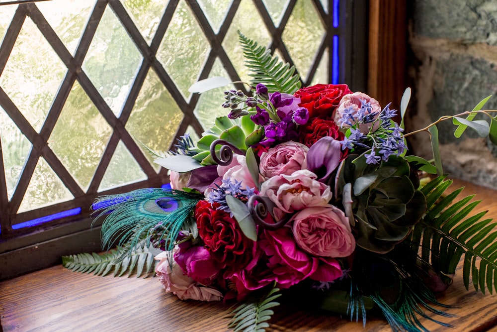 multicolored bouquet beside window