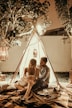 couple sitting inside tepee hut with lights