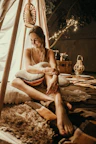Close-up of a cozy glamping tent’s interior with soft pillows, blankets, and warm ambient lighting.