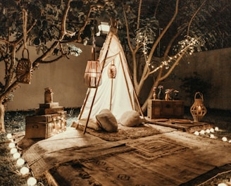 white and brown tipi tent beside trees